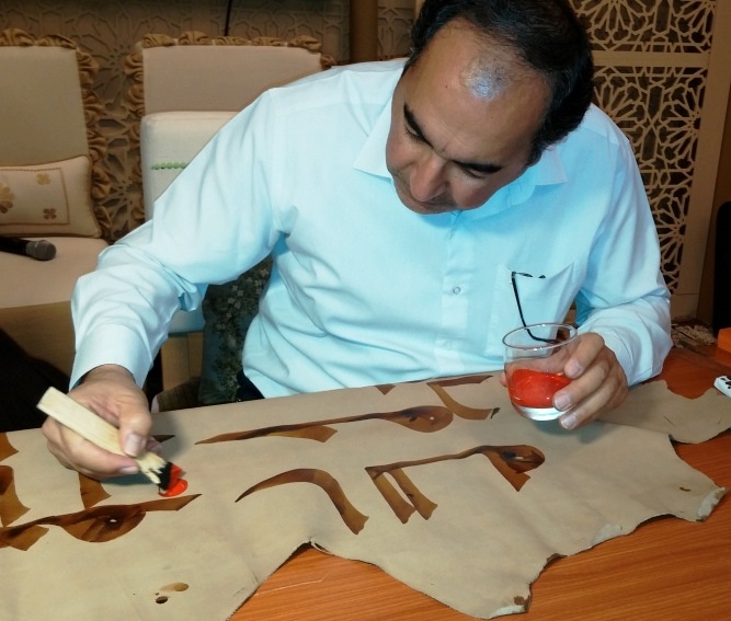 S. M. V. Mousavi Jazayeri dotting a Kufic manuscript during a workshop at the 2015 Abu Dhabi International Book Fair. Image courtesy of Kuficpedia.